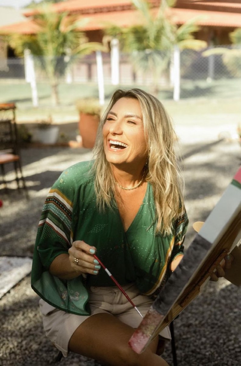 Cristine Aoni pintando uma tela ao ar livre