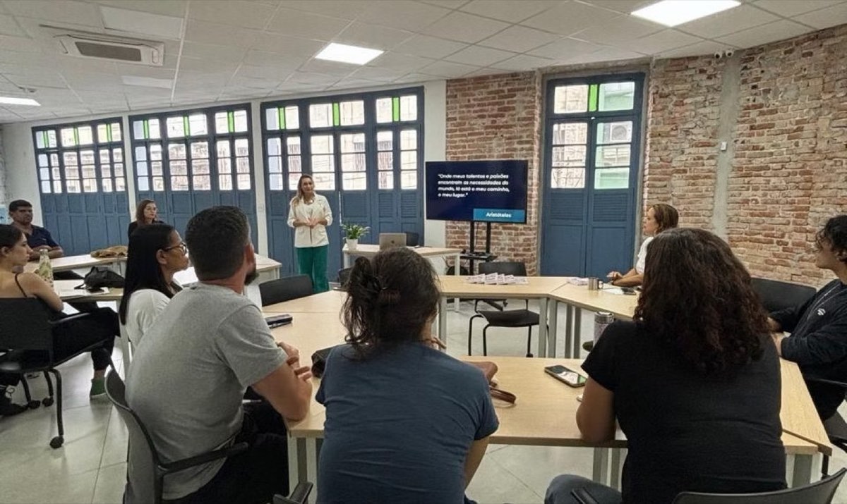 Sala de capacitação com participantes em mesas